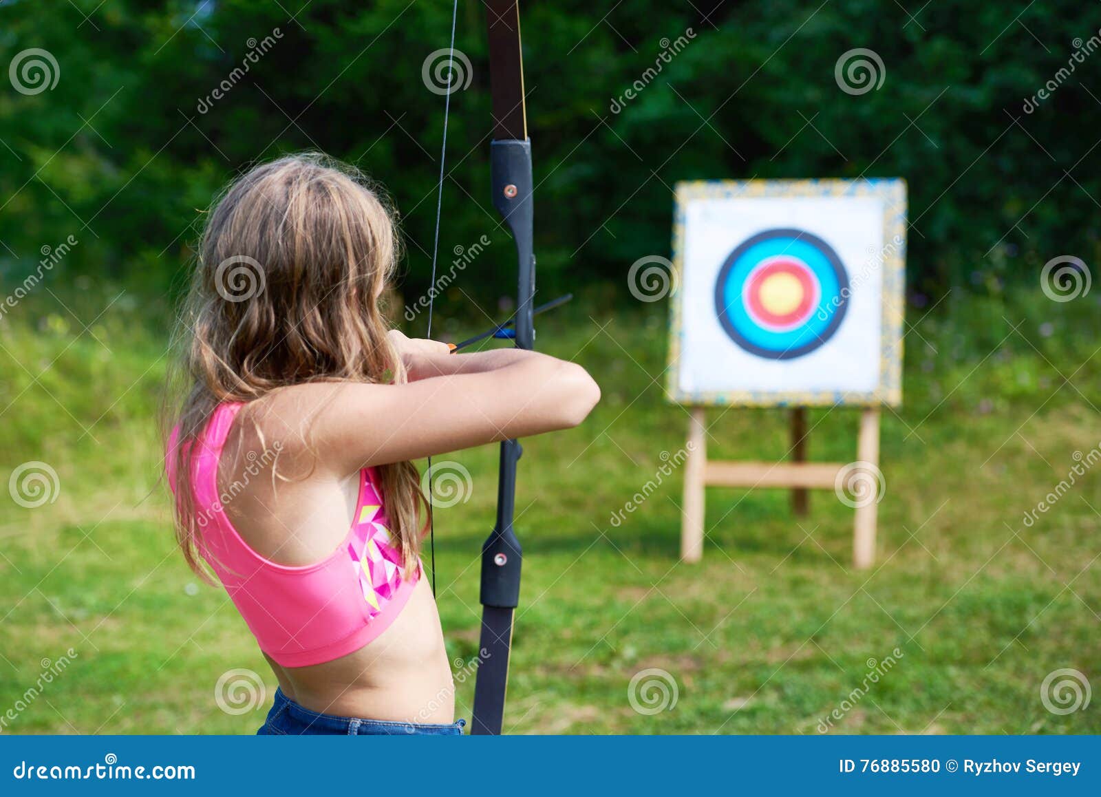 girl teenager with bow nock and aims to target