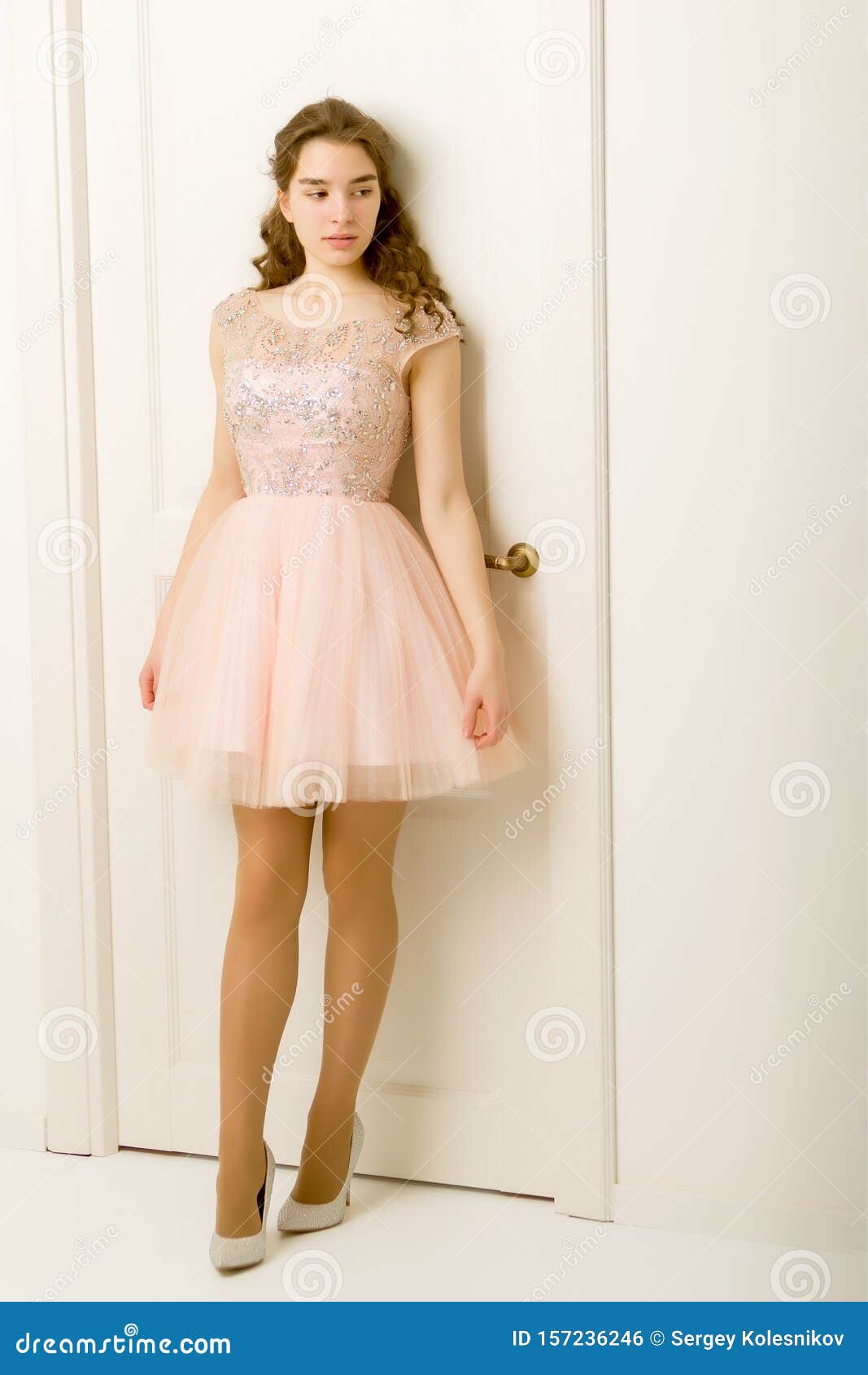 Girl Teenager in a Smart Dress Standing Near the White Door. Stock ...