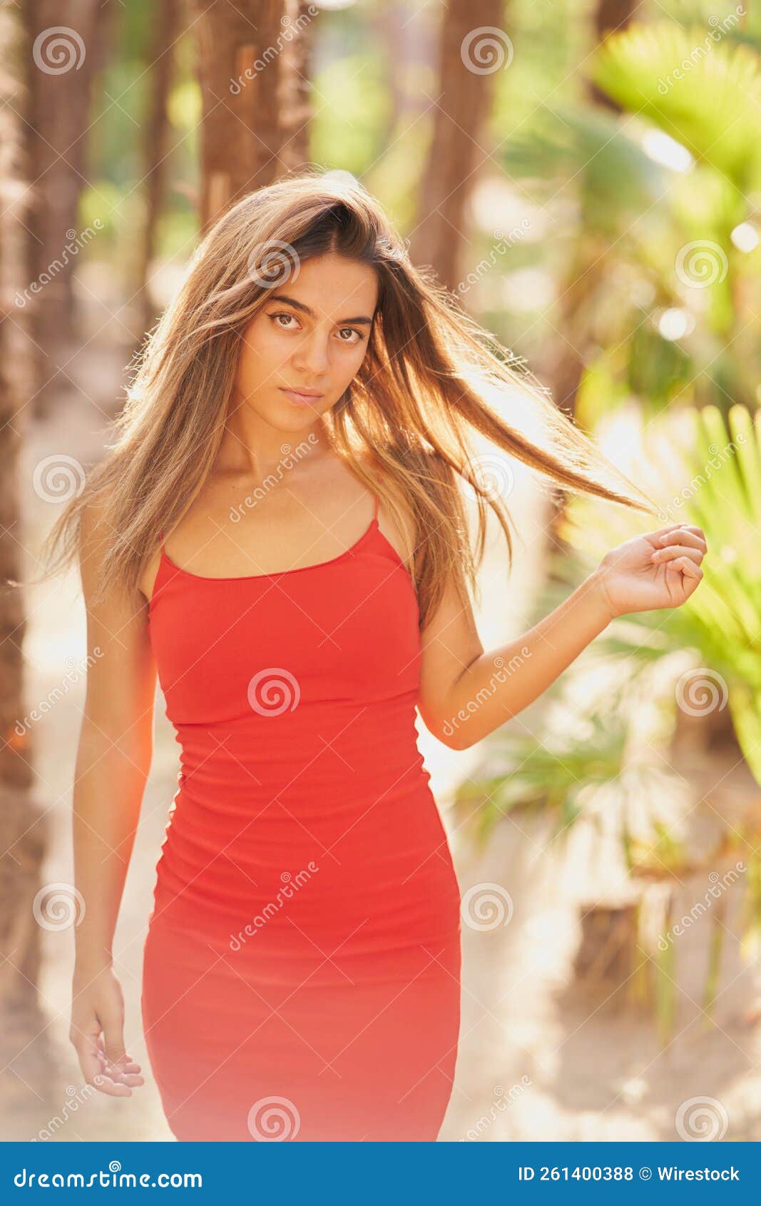 Girl With Tight Red Dress And Long Straight Hair Posing In A Park Stock