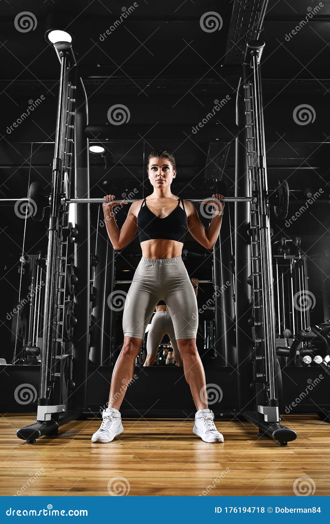 A Girl is Training Her Legs in the Gym with a Barbell. Sport ...