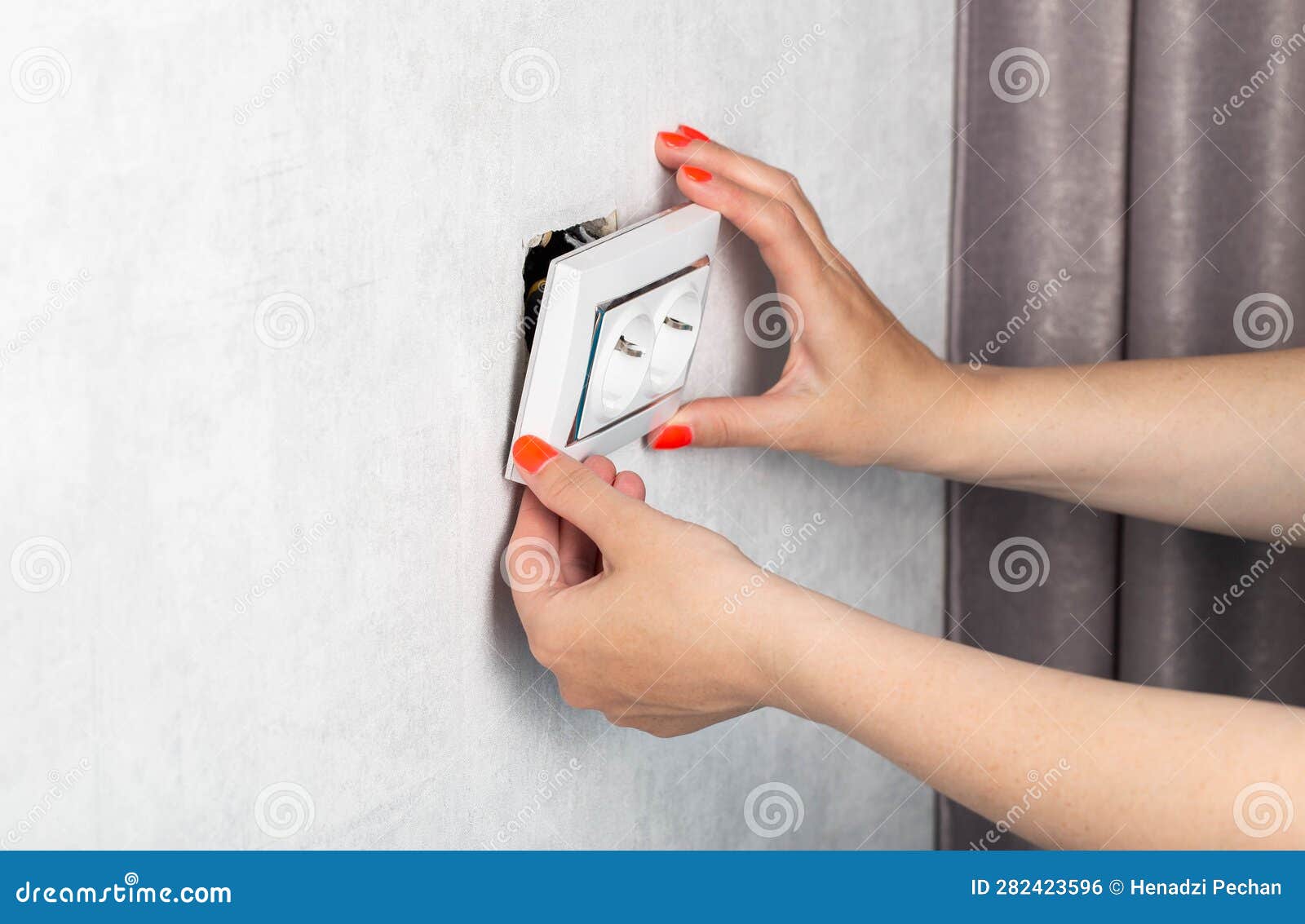 the girl is trying to insert a torn out socket from the socket due to the wrong pulling out of the electrical plug