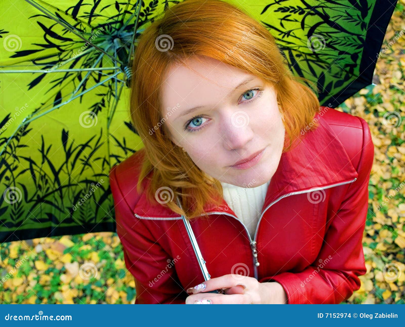 Girl with umbrella. Beautiful red girl in leather jacket with umbrella