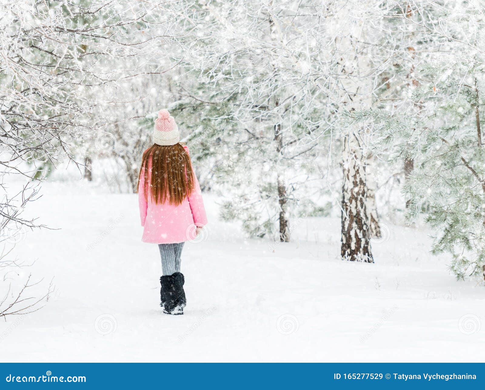 girl walking in the winter forest, backview