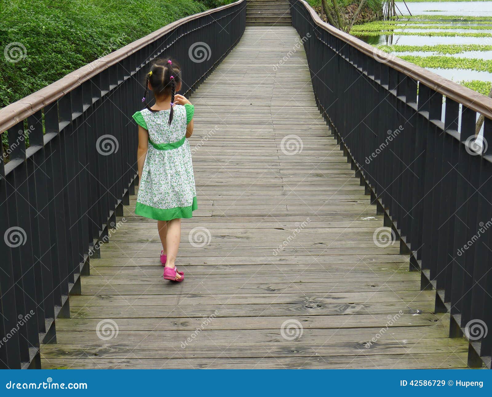 girl walking on the wooden footbridge
