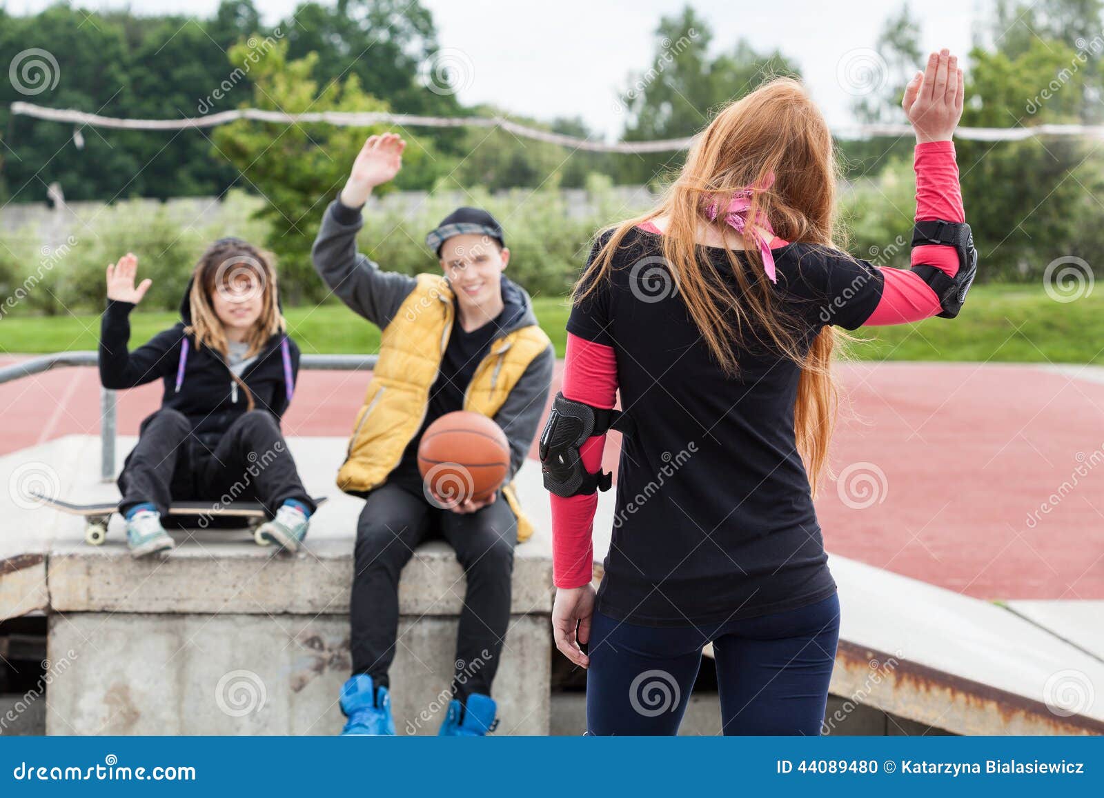 girl waving goodbye at skatepark