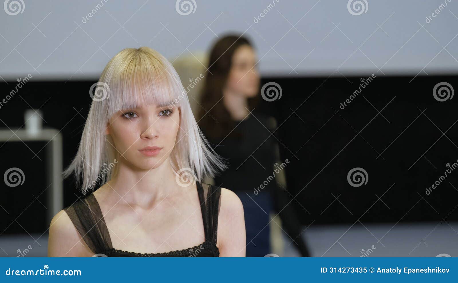 girl with white albino hair moving on runway catwalk podium. female model defile