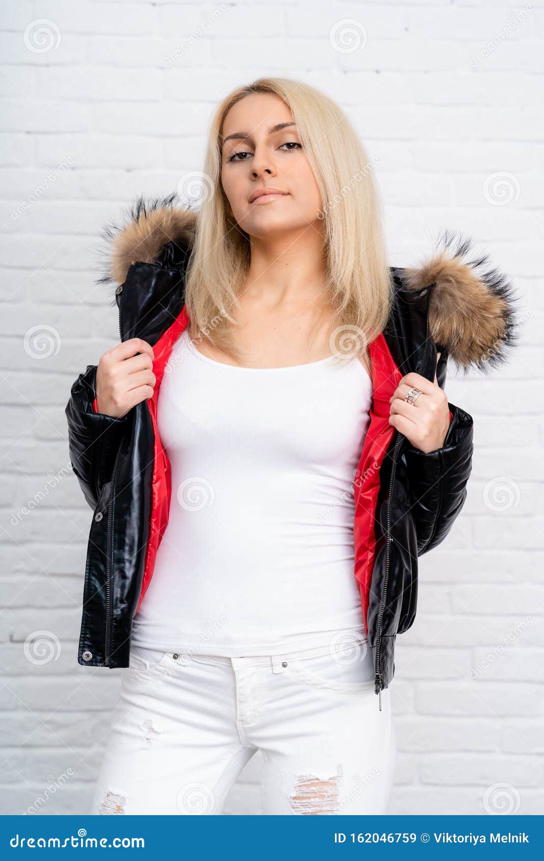 A Girl in White Jeans, a White Blouse and a Black Shiny Jacket with a ...