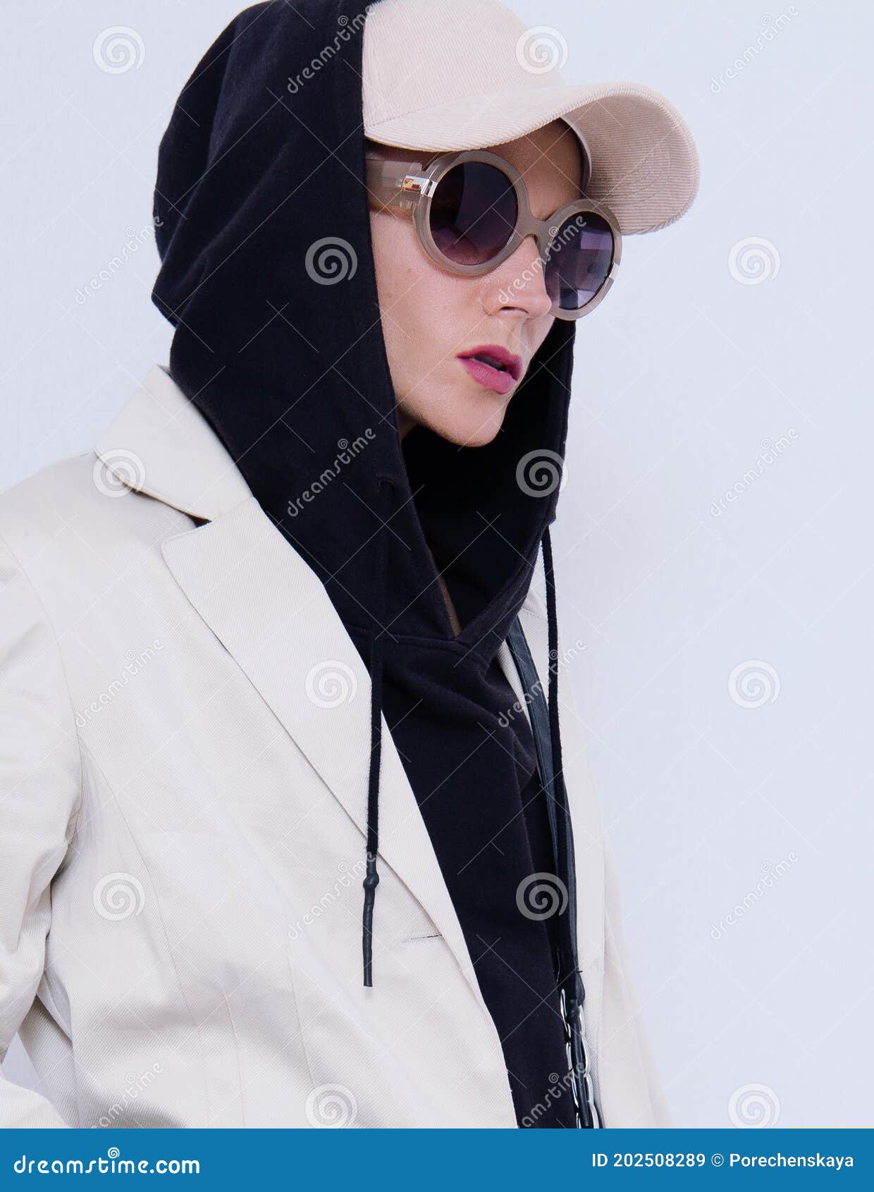Girl in White Studio. Trendy Beige Casual Outfit with Black Hoodie Accent.  Cap, Sunglasses, Denim Suit Jacket and Pants Stock Image - Image of female,  minimal: 202508289
