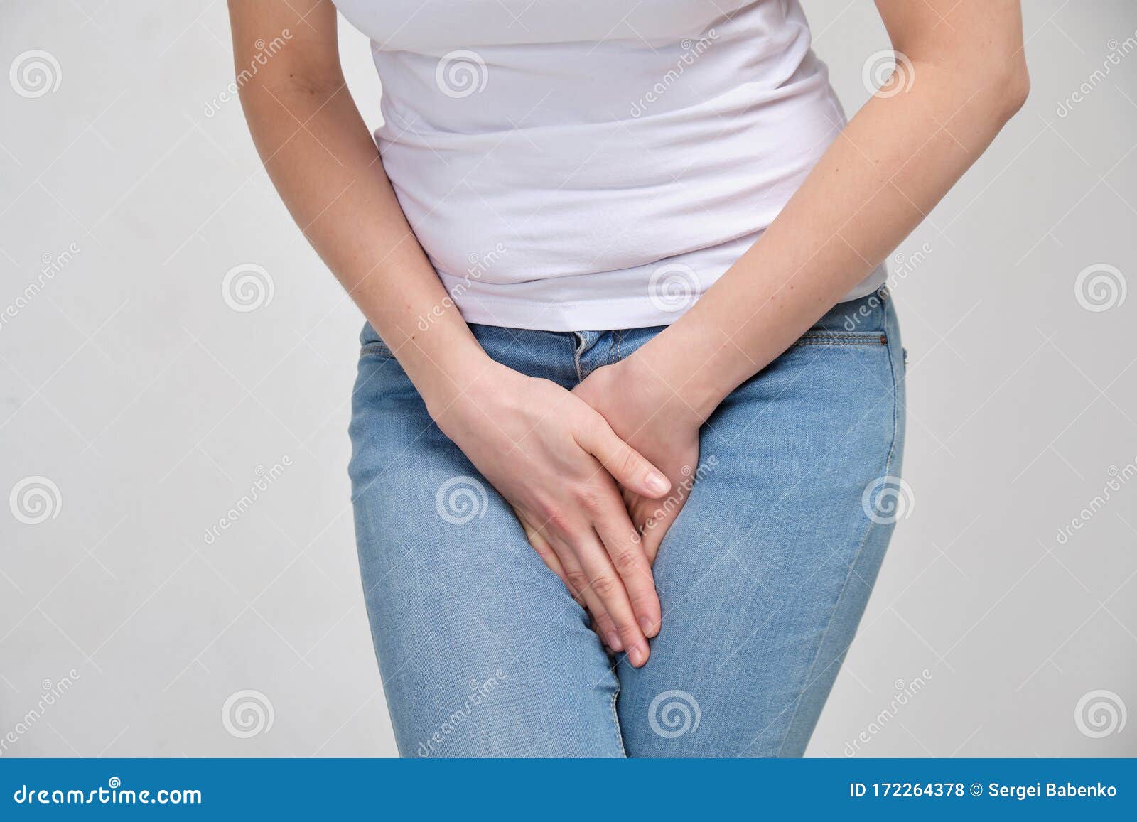 A Girl in a White T-shirt Massages the Groin. Gynecology Problems