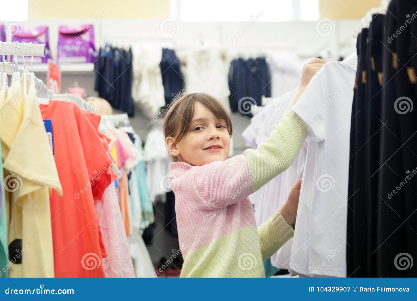 Little Girl Choosing Clothes Before School In Store Stock Image - Image ...