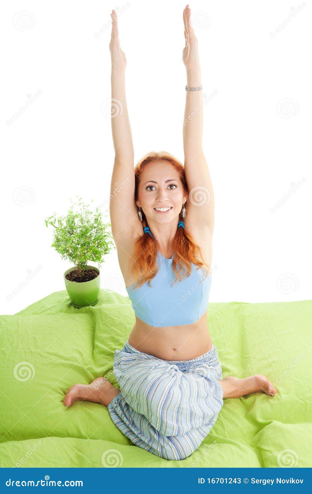 Side view of concentrated flexible women raising legs up and holding back  with hands in sarvangasana pose on mat in class for yoga stock photo