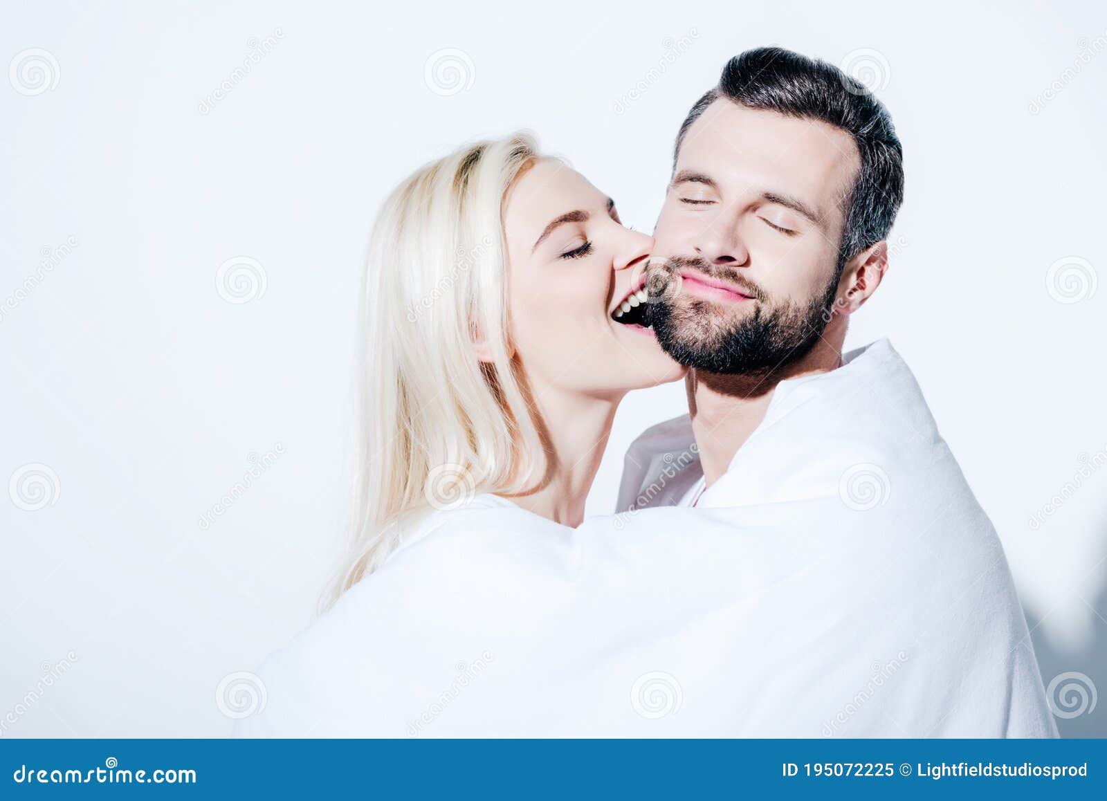 Girlfriend Biting Cheek of Boyfriend Covered in Blanket Stock Image