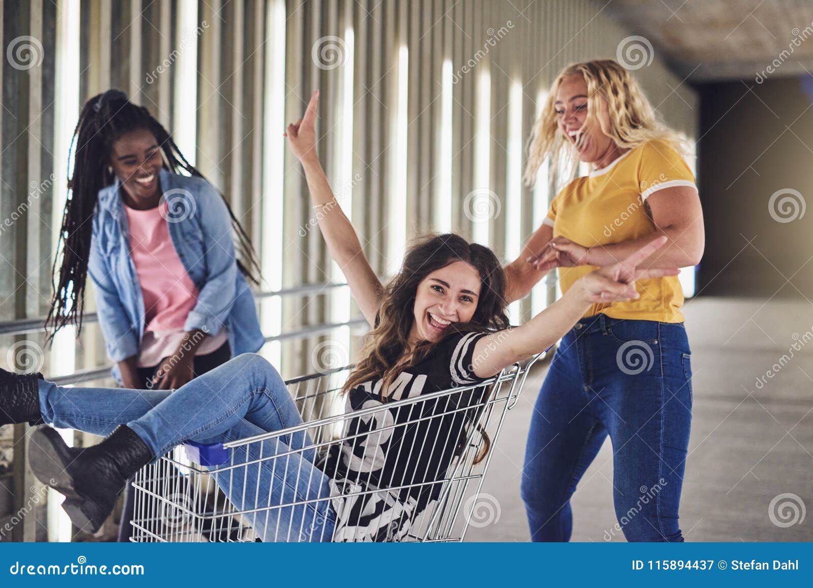 Girlfriends Having Fun With A Shopping Cart At Night Stock Image