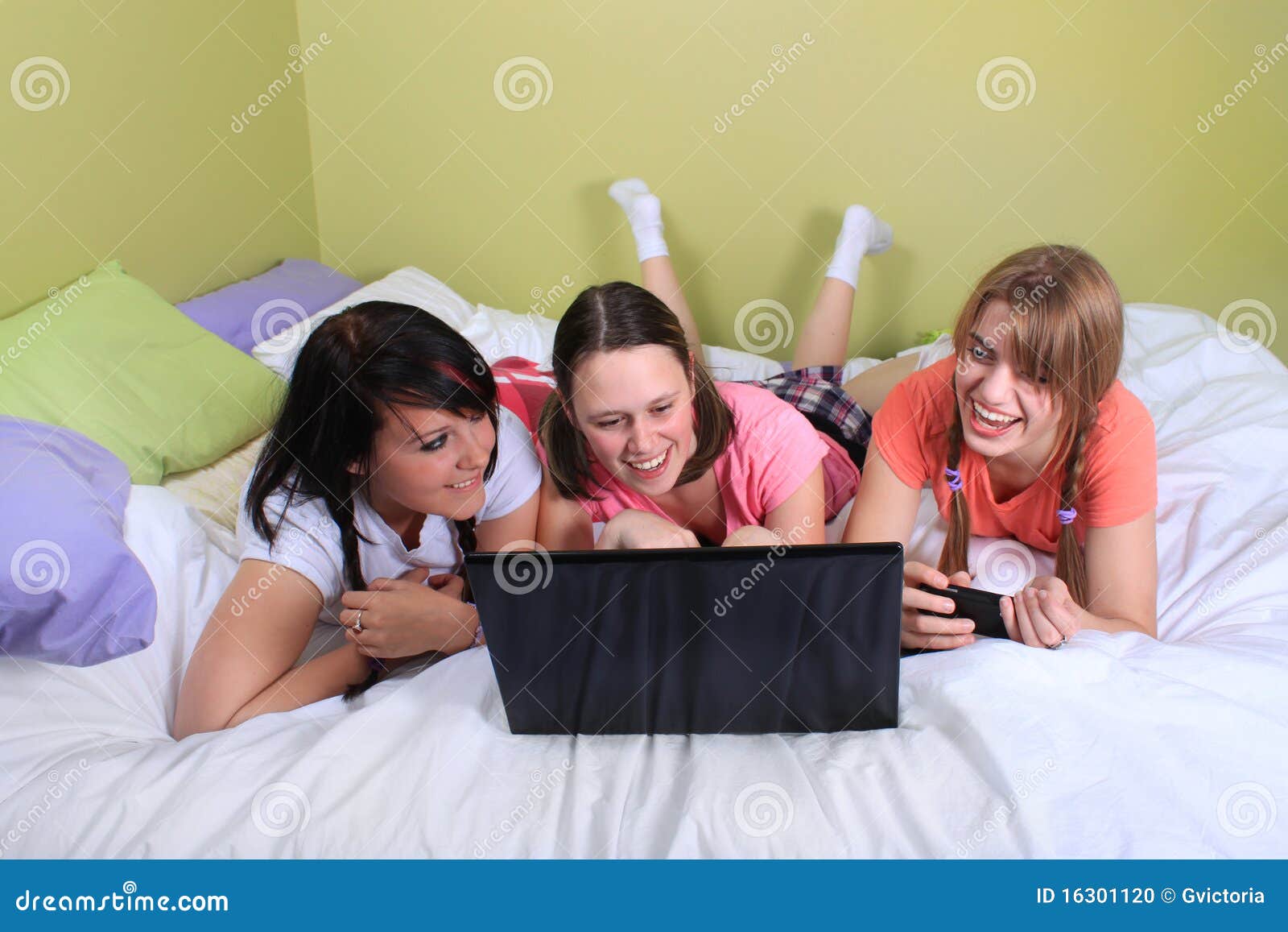 Girls on bed using laptop stock photo. Image of teenage 16301120