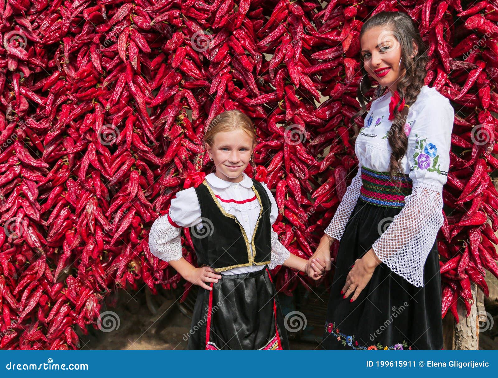 Girls Dressed On Traditional Serbian Balkan Clothing National Folk Costume Posing Near Of Lot