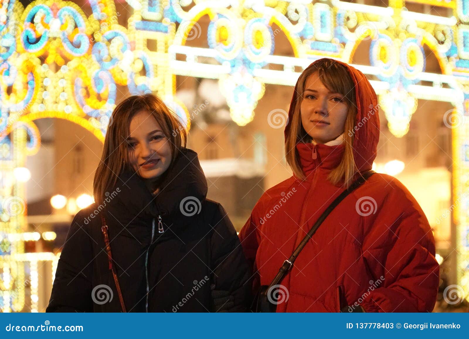 Girls Enjoying Winter Holiday Season. Blurred Christmas Lights on ...