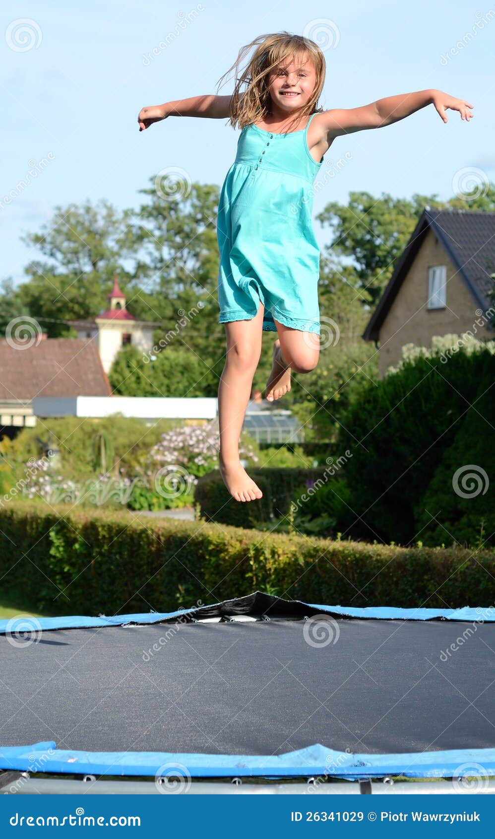 Girls fun outdoor. Cute young girl jump on garden trampoline