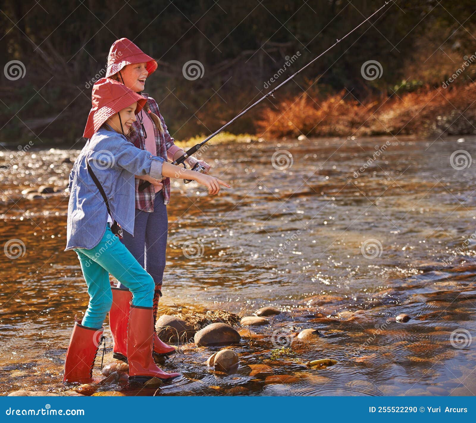 Girls Gone Fishing. Two Young Girls Fishing by a River. Stock