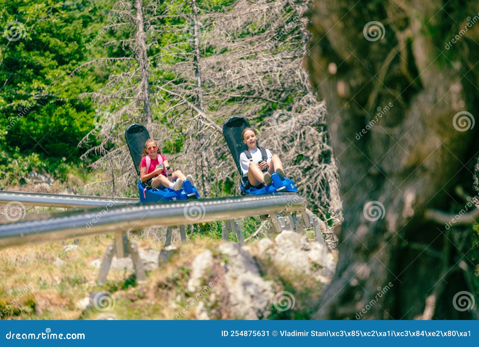 Girls Ride a Mountain Roller Coaster. Two Mountain Roller Coasters
