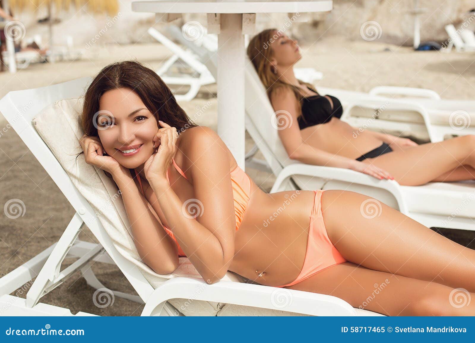 Girls sunbathing on beach stock image