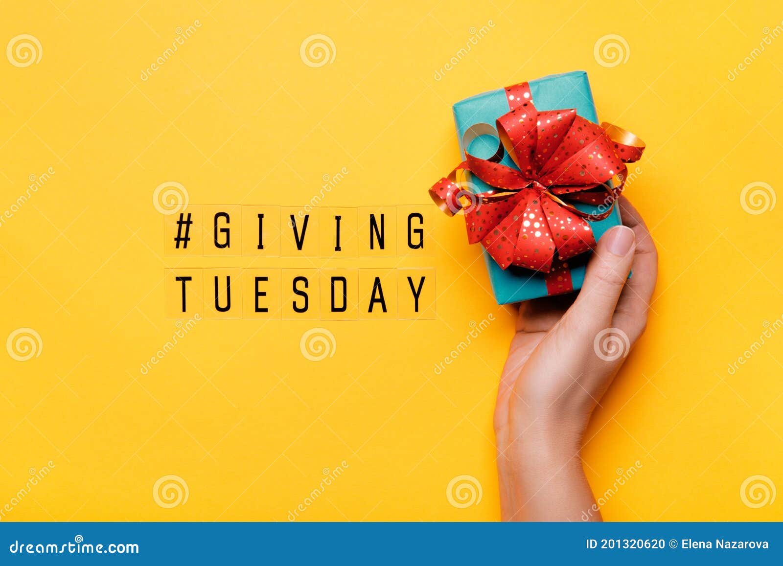 giving tuesday. global day of charitable giving after black friday shopping day. woman hand holding gift box on yellow background