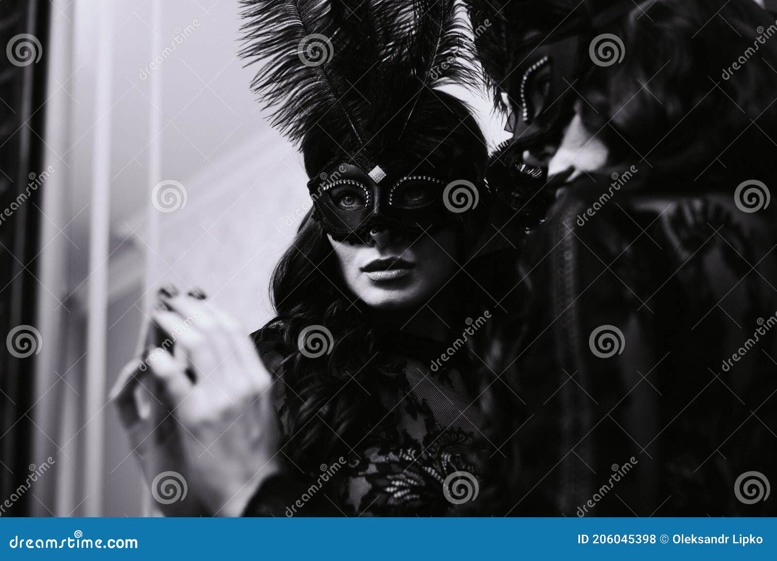 glamorous brunette lady with a beautiful hairstyle and red lips, in an evening dress, a venetian black mask with stylish accessori