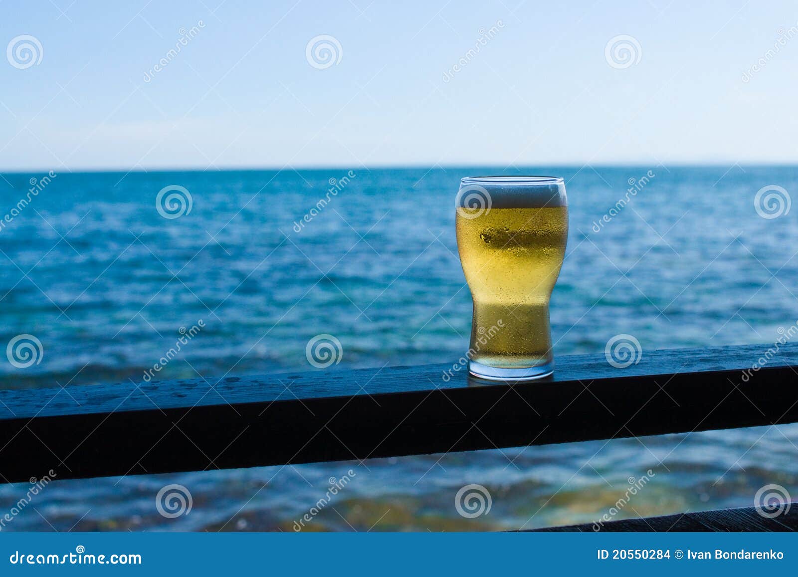 Glass of beer against sea stock photo. Image of natural 20550284