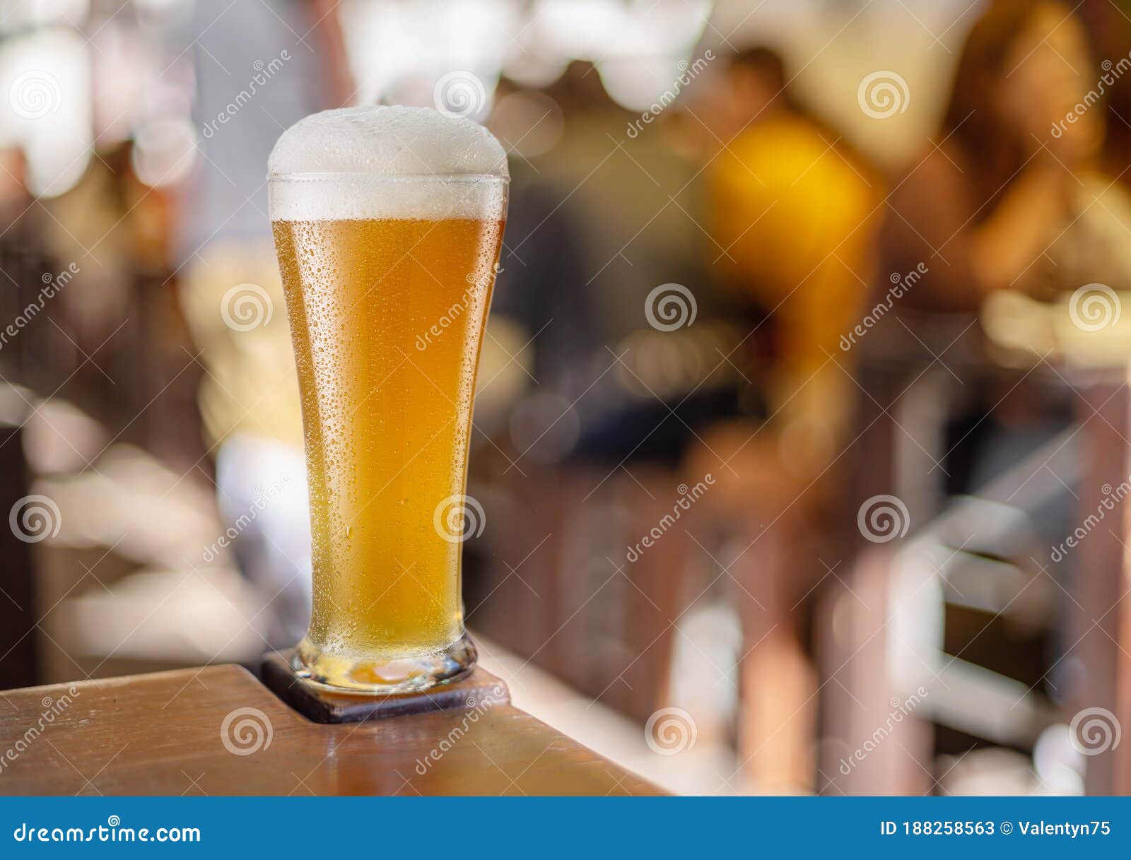 glass of beer stands on a table in a pub. white unfiltered beer