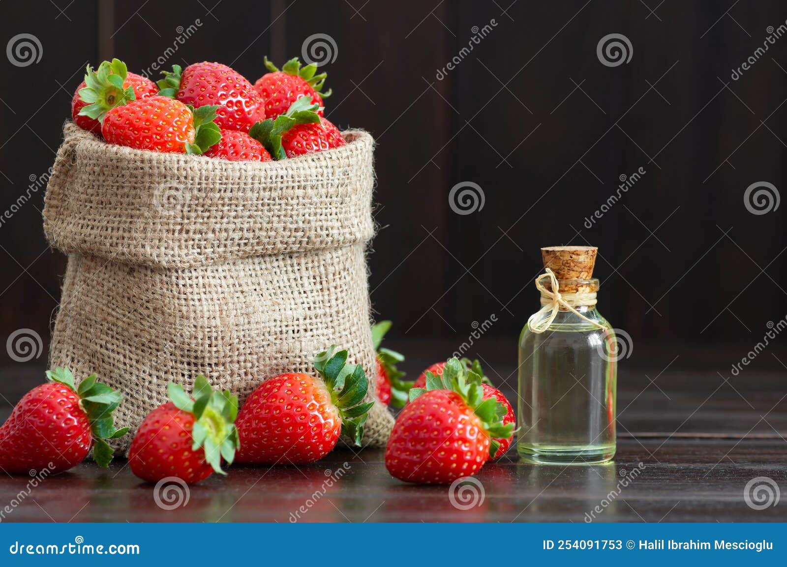 Bottle with Perfume from Strawberry Essential Oil on a Wooden Background.  Aromatherapy and Cosmetology Stock Photo - Image of bottle, floral:  189526894