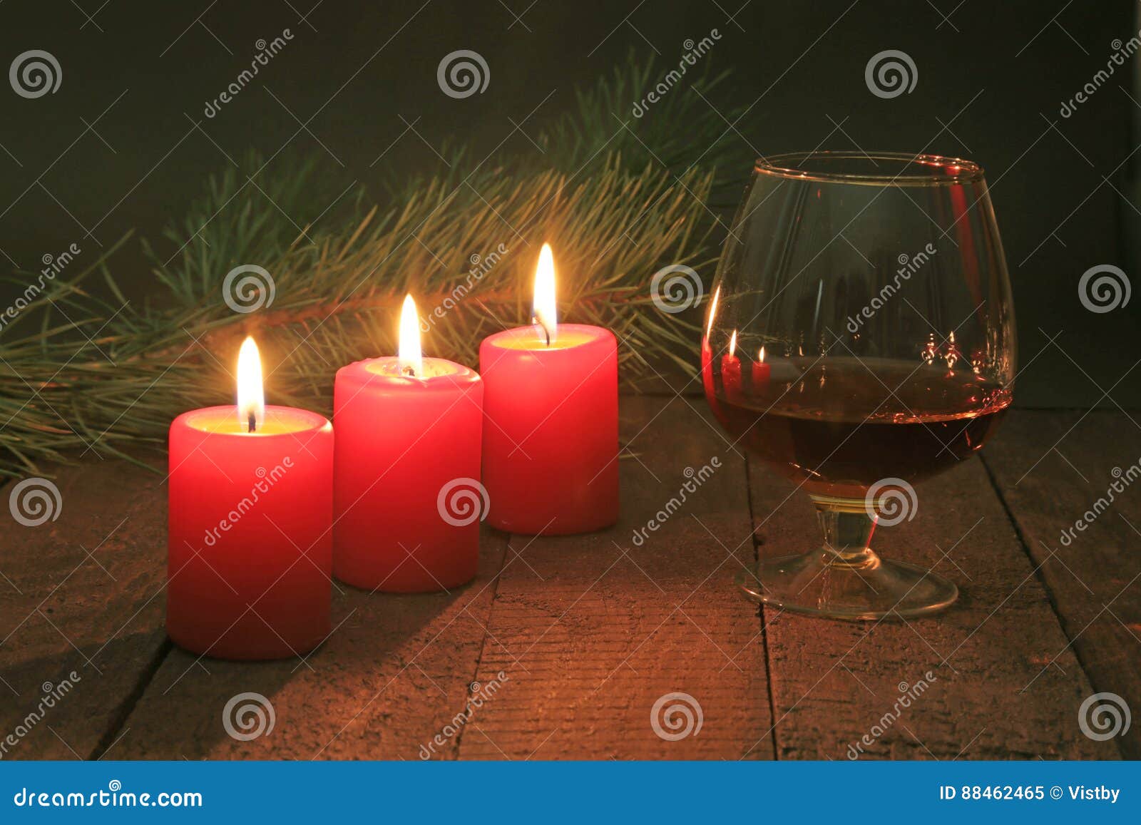 Glass of Brandy or Cognac and Candle on the Wooden Table. Celebration