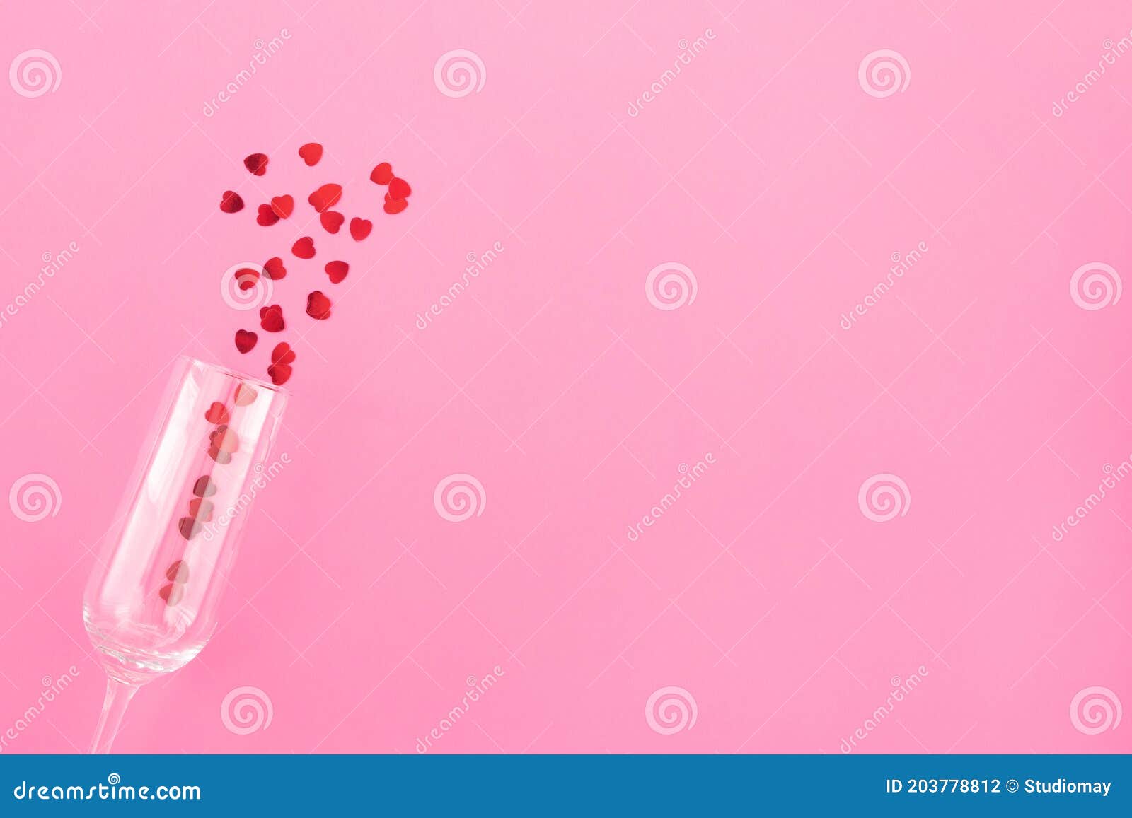 glass of champagne with red hearts on a pink background. valentines background, love, date concept with copy space, flatlay