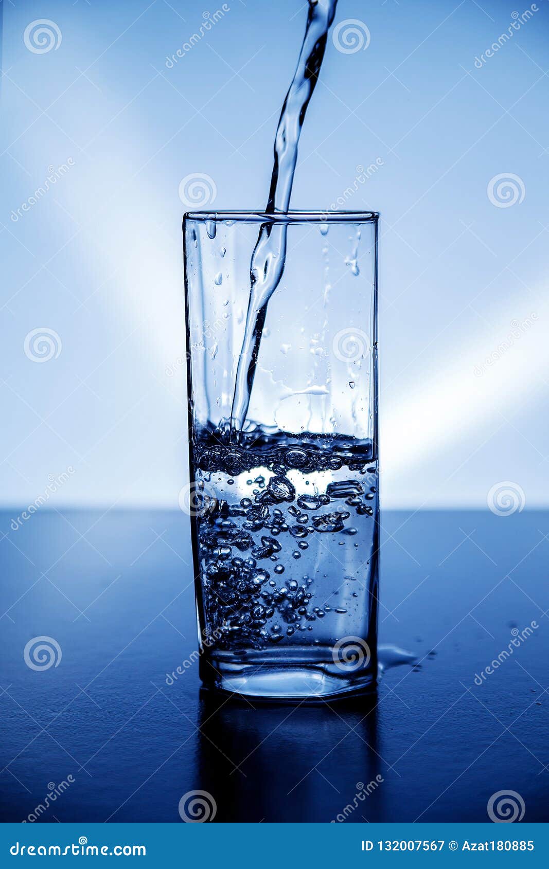 A Glass of Clean Drinking Water Illuminated with Blue Light. Stock
