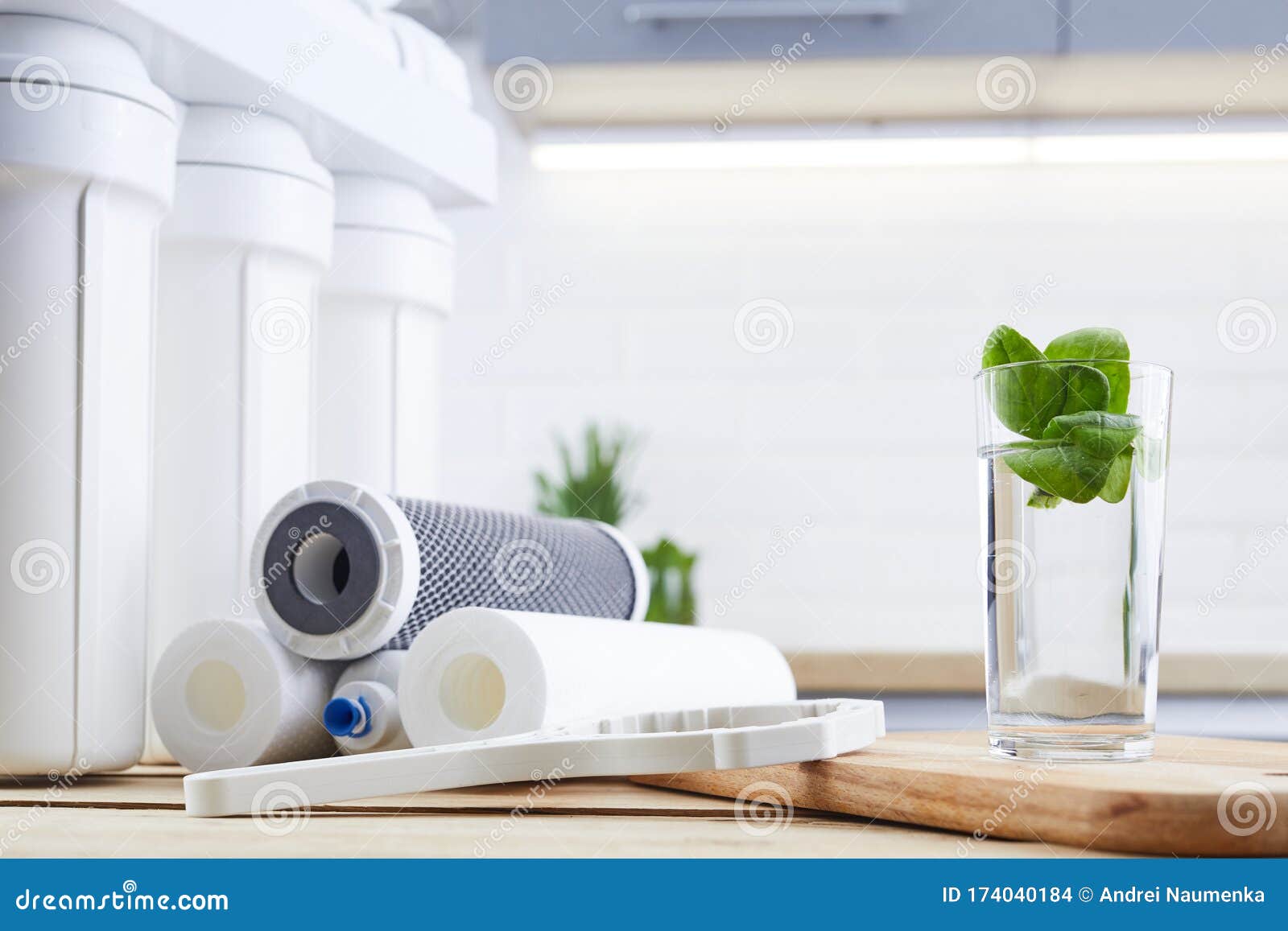 a glass of clean water with osmosis filter and cartridges a kitchen interior. concept household filtration system