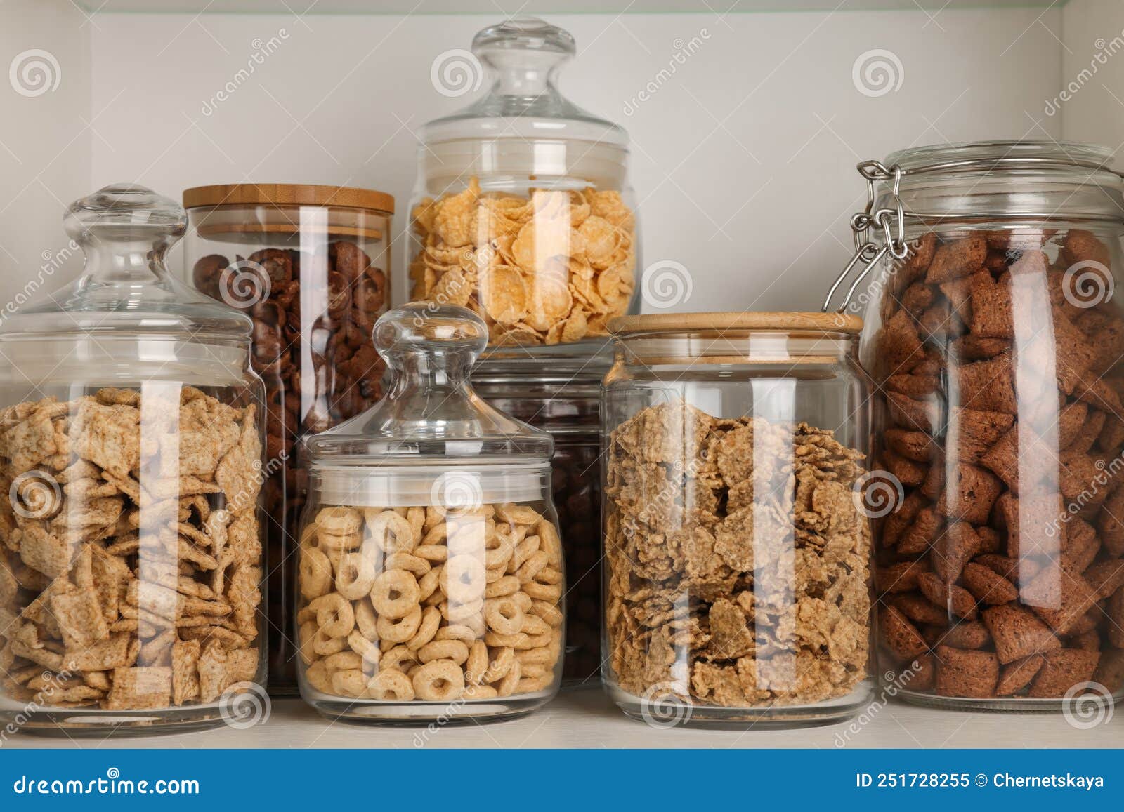 Glass Containers with Different Breakfast Cereals on Shelf Stock Image
