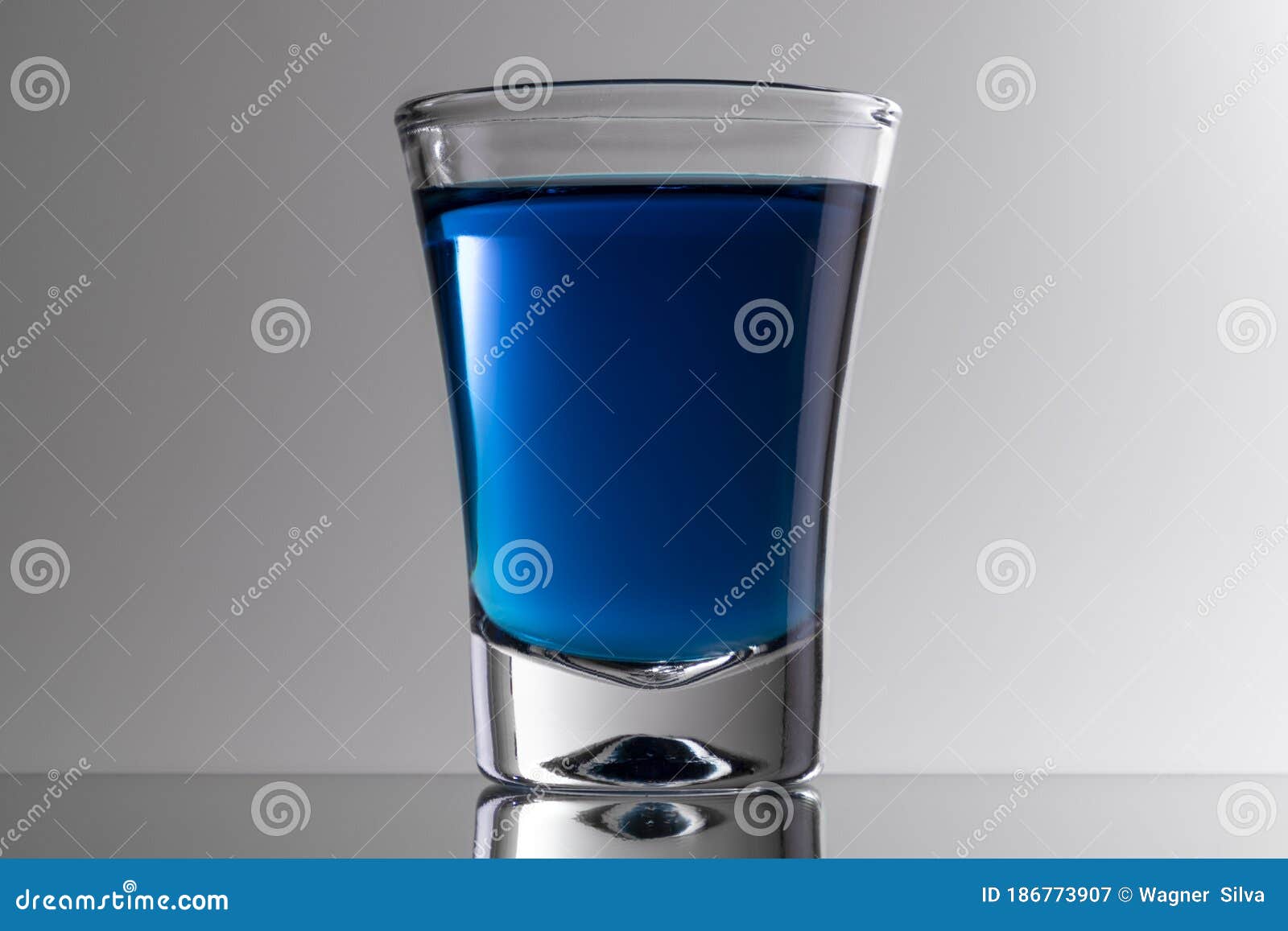 Glass cup for blue tequila stock image. Image of translucentglass 186773907
