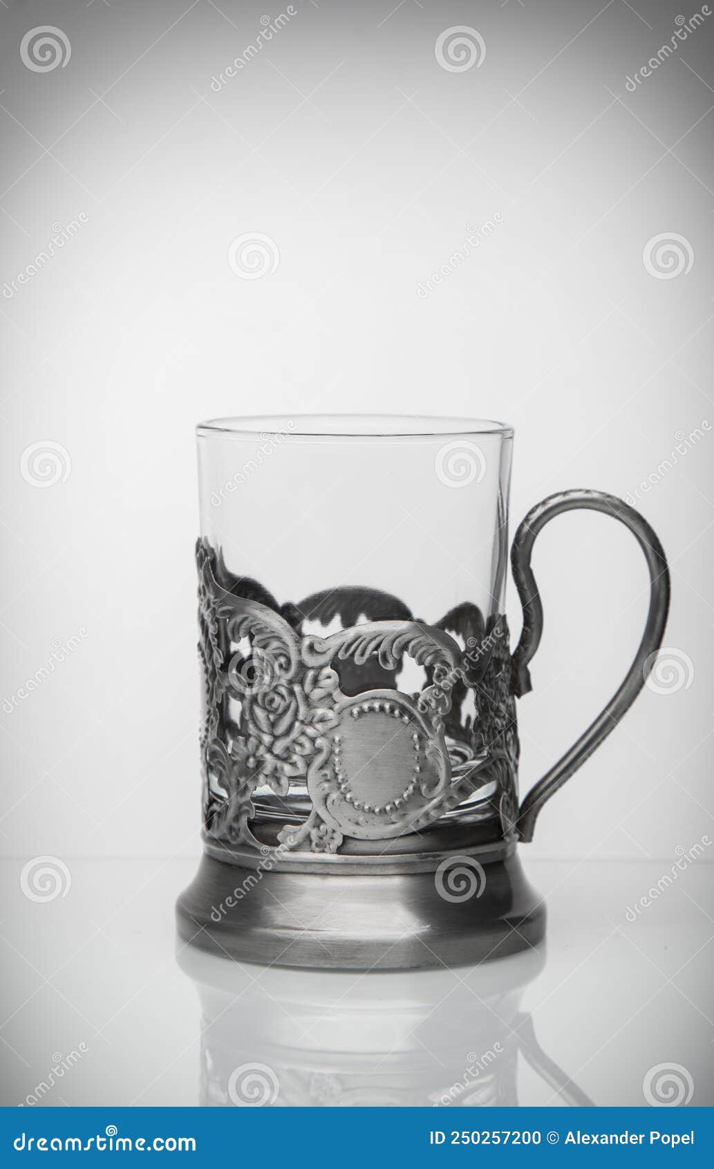 Glass Cup in a Metal Cup Holder on a Light Background Stock Photo