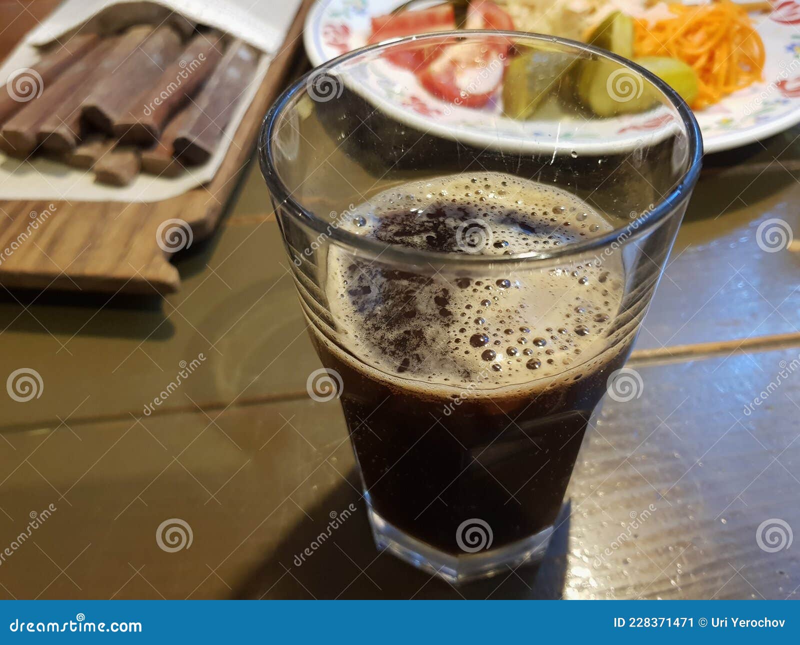 A Glass Glass with Dark Kvass on the Table in the Foreground Stock