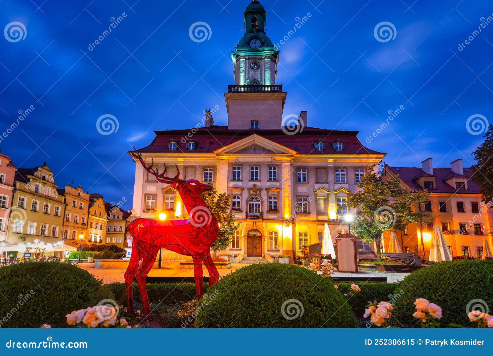 a glass deer as the emblem of the jelenia gora city on the town hall square at dusk. poland