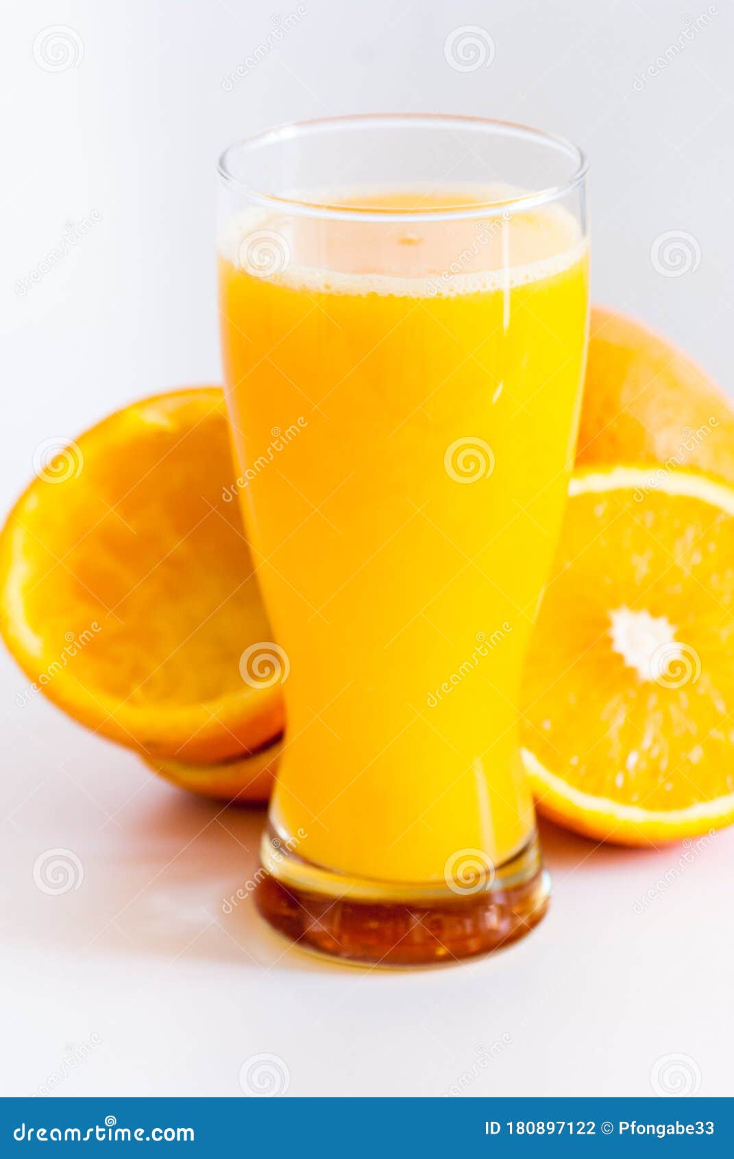 glass with fresh squeezed orange juice and oranges on white healthy life concept