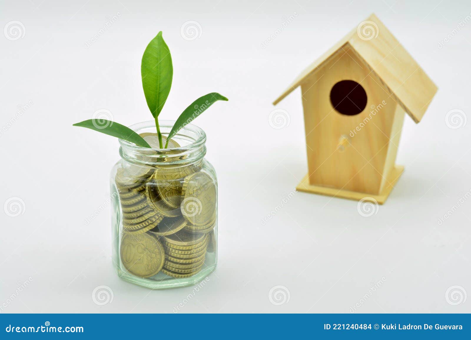 glass jar full of coins and a miniature wooden house