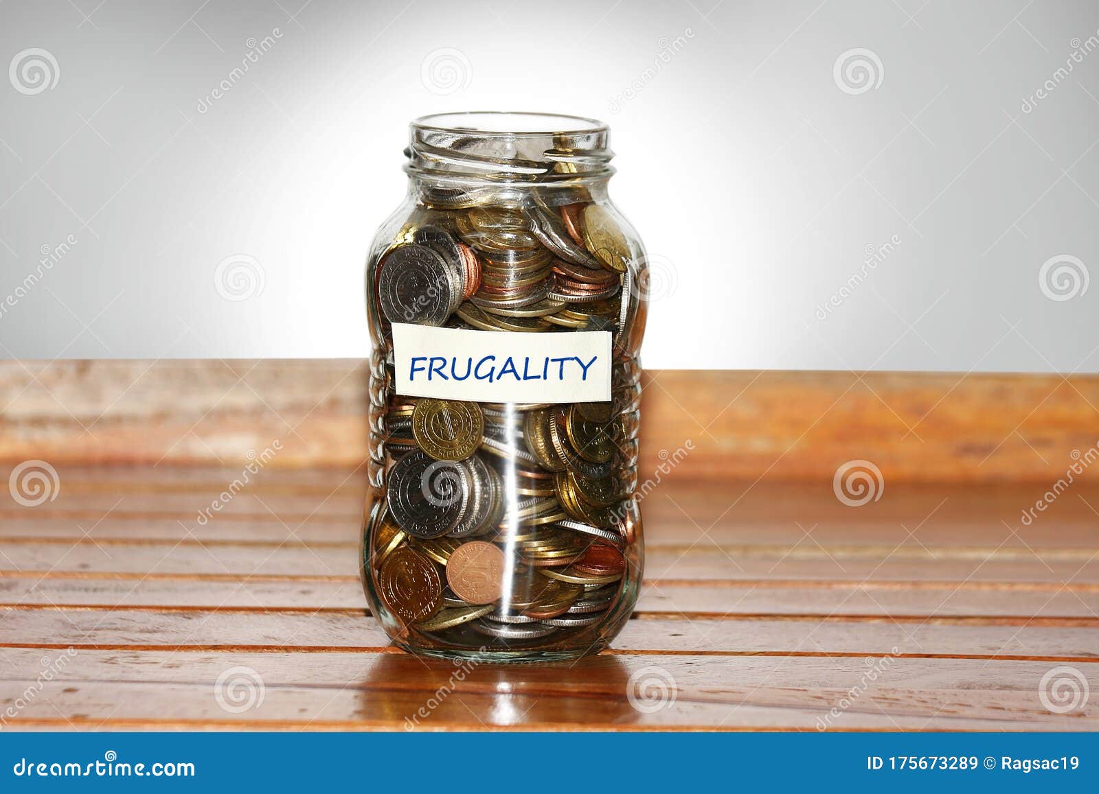 a glass jar full of coins to represents frugality