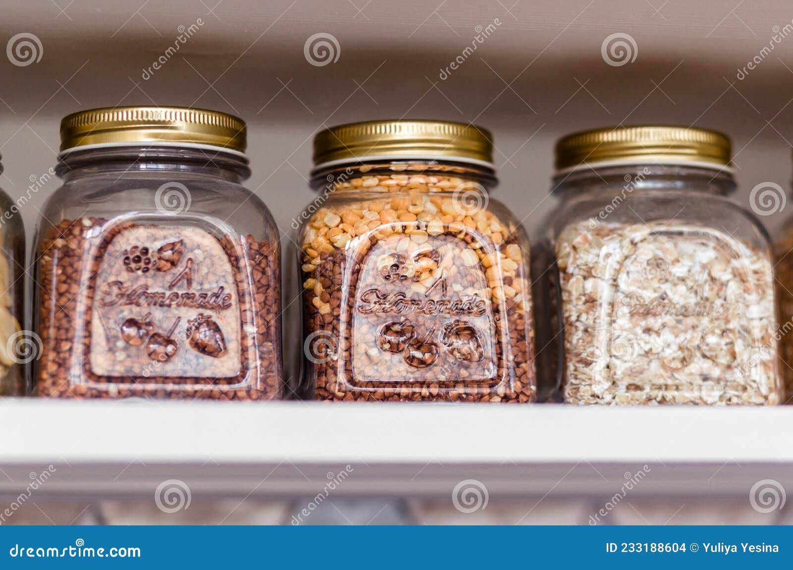 Glass Jars of Cereals are on the Shelf in the Kitchen Stock Photo