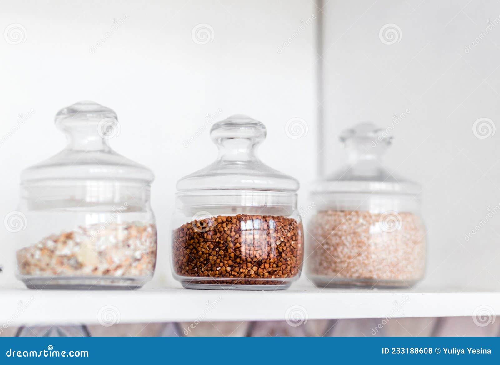 Glass Jars of Cereals are on the Shelf in the Kitchen Stock Photo