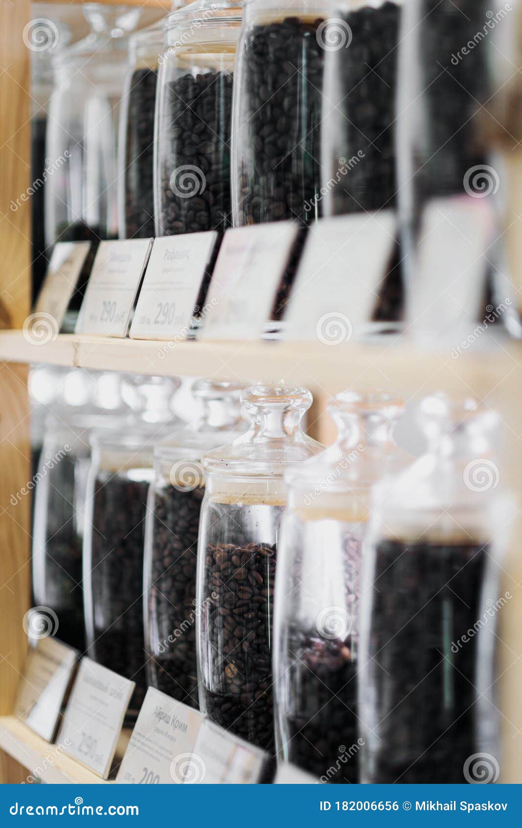 Glass Jars of Coffee Beans Stand on the Shelf of the Store. Stock Photo