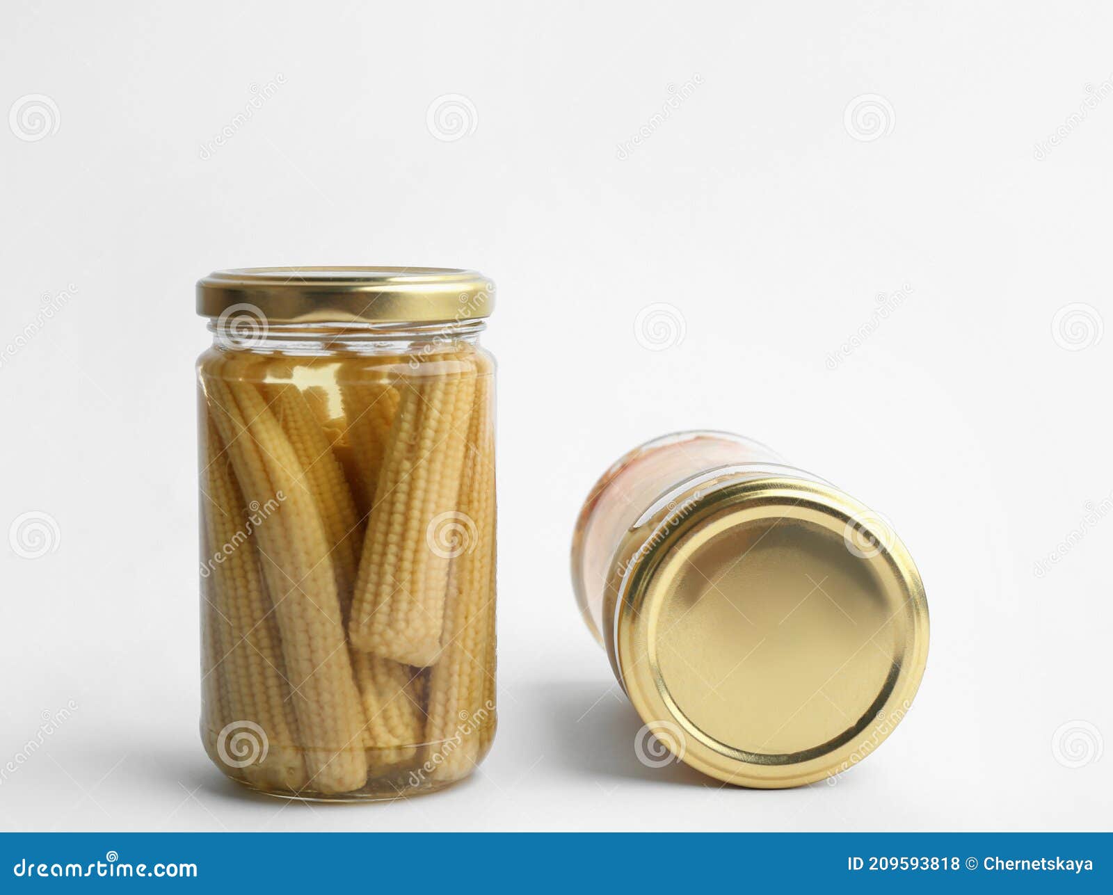 Glass Jars with Pickled Baby Corn on White Background Stock Photo