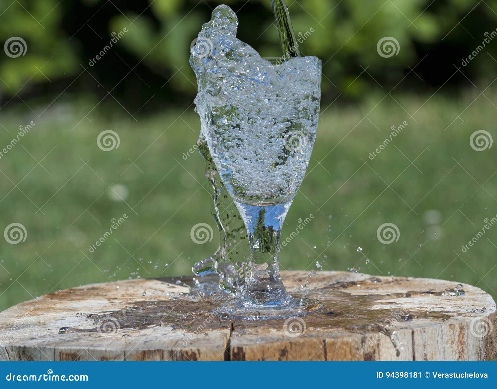 Glass mineralvatten. Exponeringsglas med mineralvatten - färgstänk