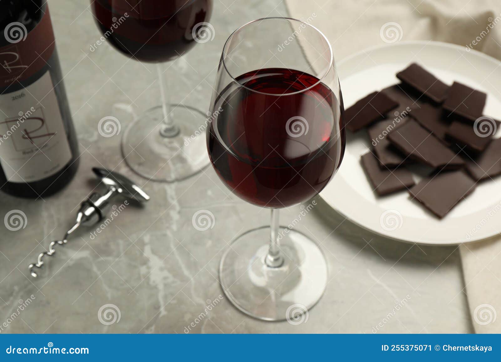 Glass of Red Wine with Chocolate on Light Marble Table Stock Image