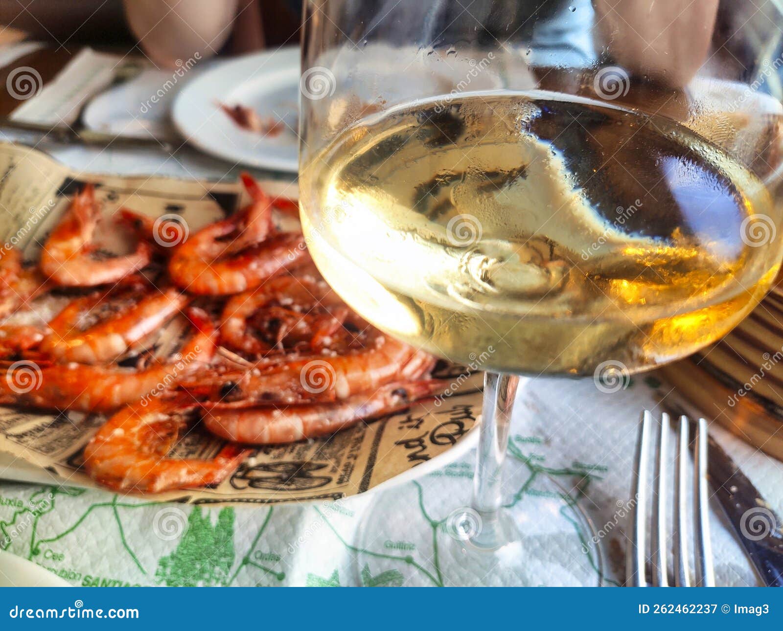 glass of ribeiro wine and grilled prawns in a restaurant in olveiroa village, dumbria municipality, galicia, spain