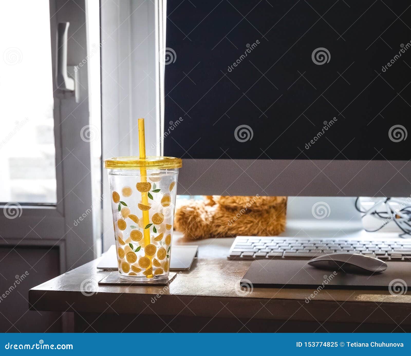 A Glass With A Straw With Painted Lemons On The Desk Of The Home