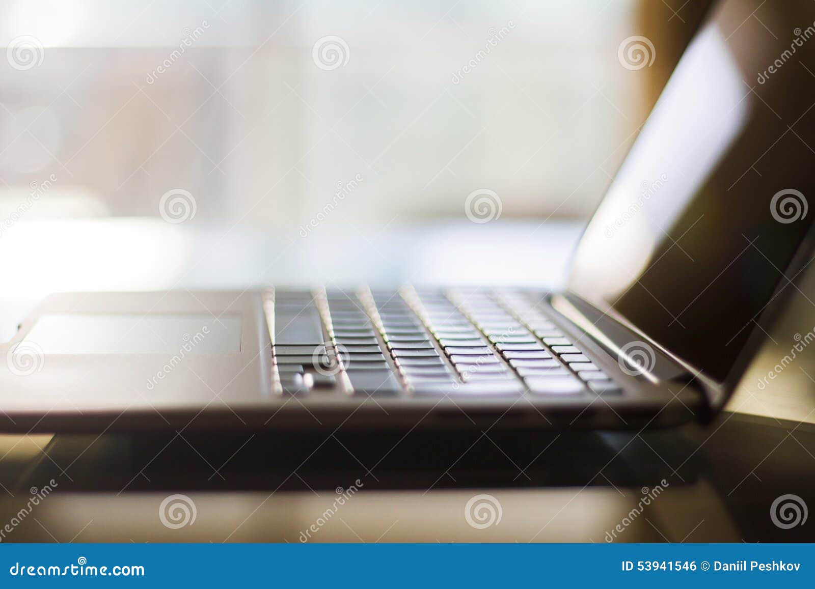 A glass table with a laptop, shallow depth of field, close up